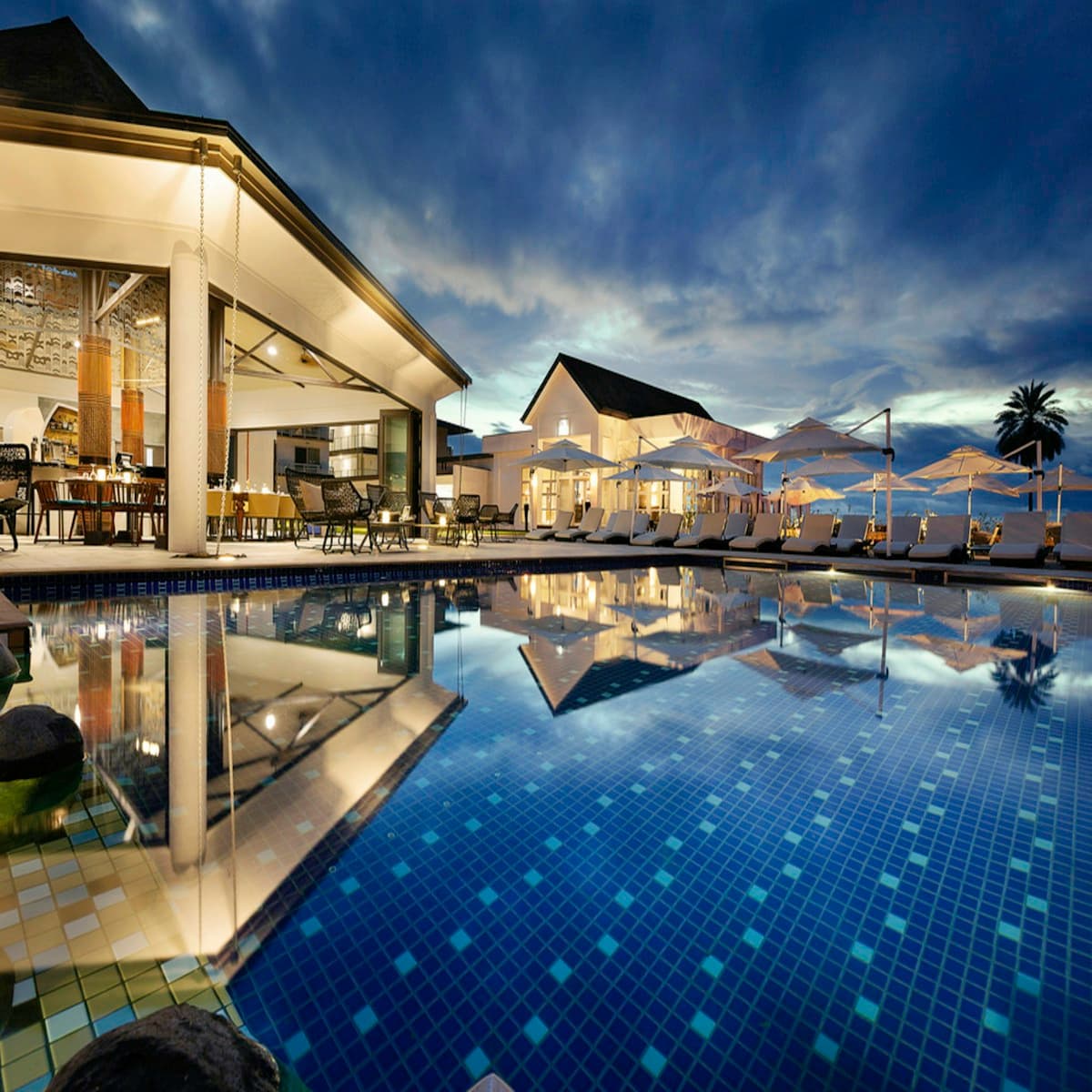Luxury resort pool area surrounded by tropical greenery